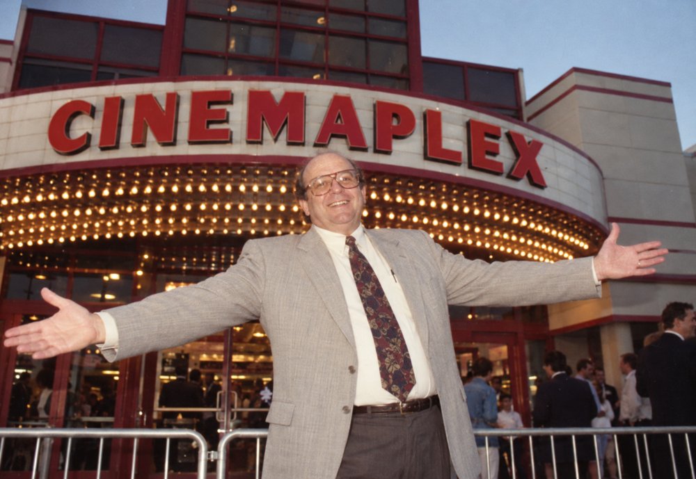 Frank with arms outstretched in front of the Cinemaplex marquee