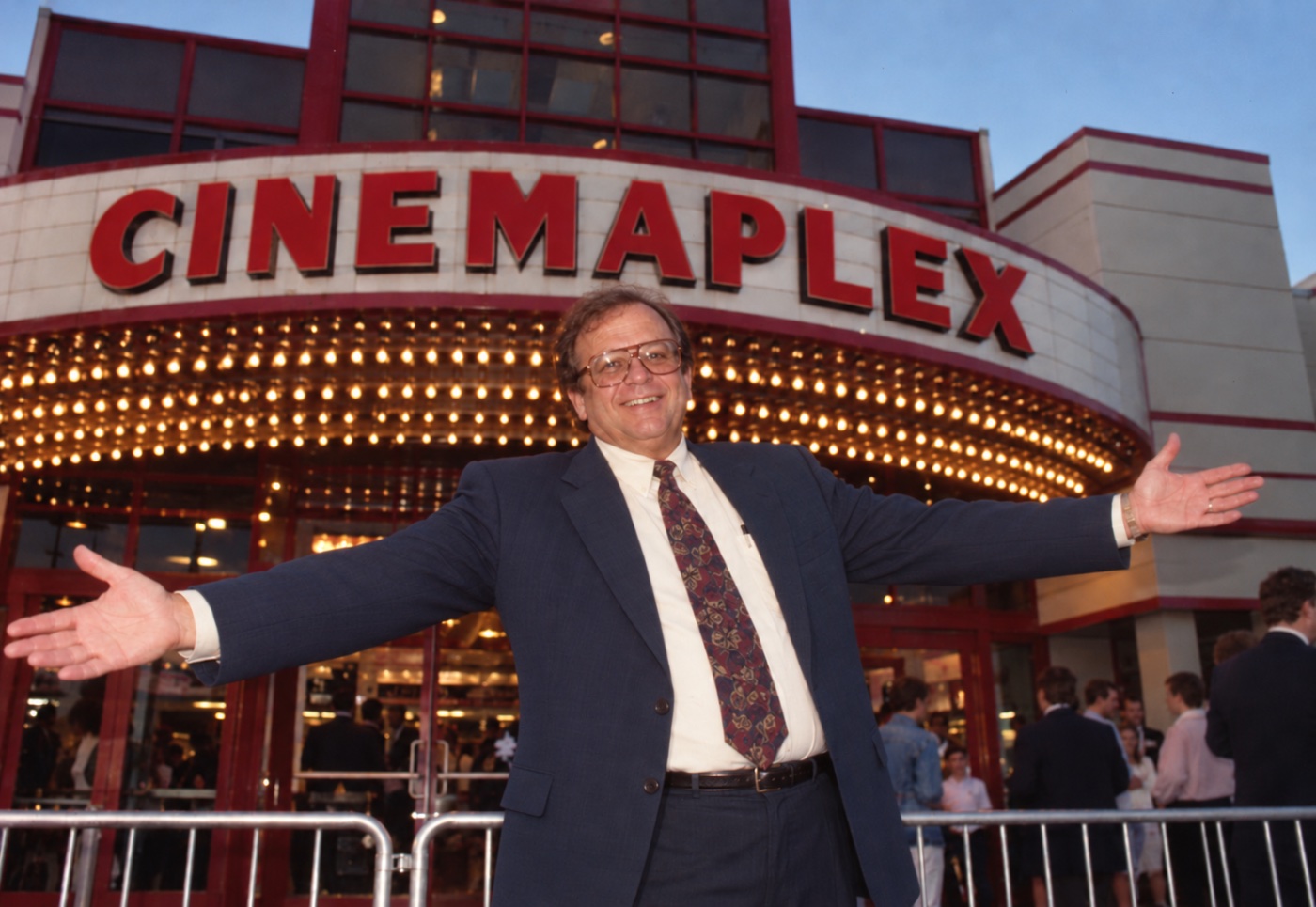 Frank with arms outstretched in front of the Cinemaplex marquee